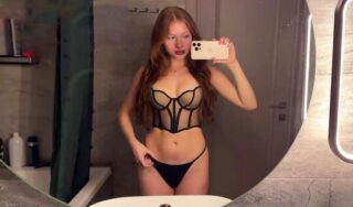 A red-haired minx in lingerie perfectly sucks the trunk of her chosen one